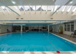 a large pool with blue water in a building at Lupin in Saint Wenn