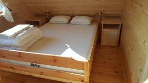 Habitación pequeña con 2 camas en una cabaña en Rajskie Domki en Gąski