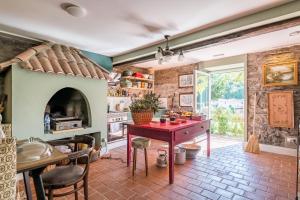 a kitchen with a red table and a fireplace at Villa Camélia Boutique House in Camacha