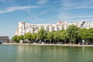 um grande edifício ao lado de uma massa de água em ibis Paris La Villette Cité des Sciences 19ème em Paris