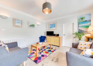 a living room with a couch and a table at Pebbles Marazion in Marazion