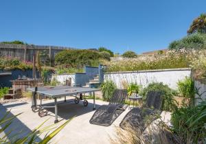 a ping pong table and chairs in a garden at Pen Y Mor in Mawgan Porth