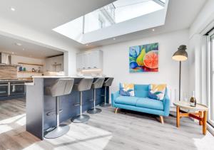 uma cozinha e sala de estar com um sofá azul e um balcão em Heyl Sound em Padstow
