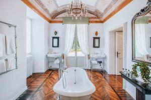 baño con bañera, 2 lavabos y lámpara de araña en Ludwig House en San Pietro in Cariano