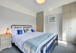 a bedroom with a large bed with blue pillows at 6 St Saviours Lane in Padstow