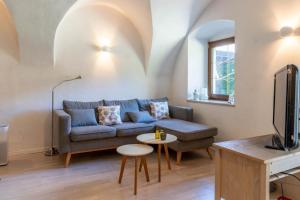 ein Wohnzimmer mit einem Sofa und einem Tisch in der Unterkunft Il Giardino ai Volti 1T, Caldonazzo Ospitar in Caldonazzo
