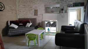 a living room with a couch and a table and chairs at Holiday home Aqueducienne in Ahuy