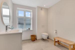 a bathroom with a sink and a toilet and a mirror at Søndergade 8, 1 Sal in Løkken +32 photos