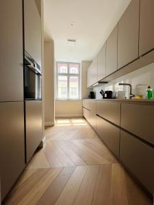 een keuken met houten vloeren en een groot raam bij Luxury Home / 3-Raum-Suite an der Frauenkirche / 2 in Dresden