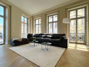 a living room with a black couch and a table at Luxury Home / 3-Raum-Suite an der Frauenkirche / 2 in Dresden