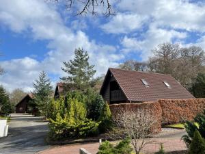 ein Haus mit einem braunen Dach und einigen Büschen in der Unterkunft Loch Lomond Luxury Lodges in Drymen