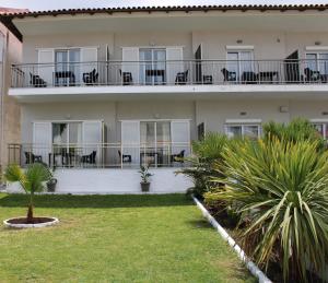 a building with chairs and tables on the balcony at Villa Thalassa Apartments in Pefkochori