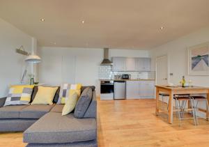 a living room and kitchen with a couch and a table at The Lookout - Sennen in Sennen