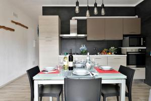 een keuken met een witte tafel met stoelen en een eetkamer bij KT House - Tortolì in Tortolì