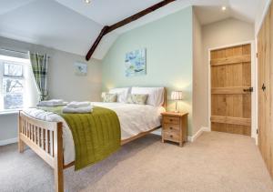 a bedroom with a bed and a wooden door at Otterbridge in Saint Breward