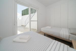 una stanza bianca con due letti e una finestra di Bonita a Avileses Altre 14 foto