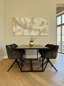 een eettafel met stoelen en een vaas erop bij Luxury Home / 3-Raum-Suite an der Frauenkirche / 2 in Dresden