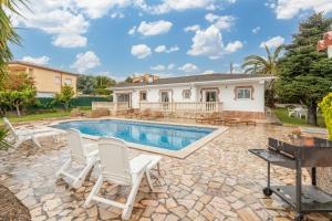 a backyard with a swimming pool and chairs and a house at Villa Terrassa in Sant Antoni de Calonge