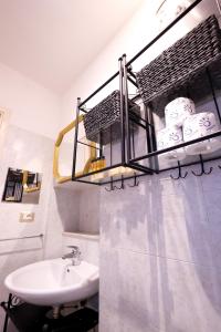 een badkamer met een wastafel en een plank met handdoeken bij Sant'Ambrogio Loft in Florence