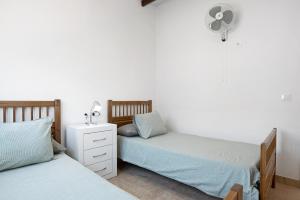 1 dormitorio con 2 camas individuales y ventilador en Casa Naranjos, en El Soto