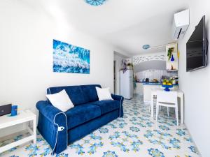 Blue Waves في بوسيتانو: غرفة معيشة مع أريكة زرقاء ومطبخ