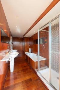 La salle de bains est pourvue de 2 lavabos, d'une baignoire et d'une douche. dans l'établissement Les Résidences première ligne, à Andernos-les-Bains