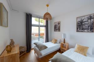 een woonkamer met 2 bedden en een raam bij Les Résidences première ligne in Andernos-les-Bains