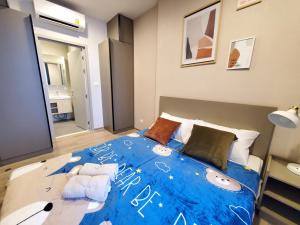 a bedroom with a large bed with a blue comforter at Sukhumvit 36,Japanese style condominium,central area,high-rise view,BTS Thonglo in Bangkok