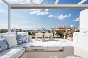 a couch on a balcony with a view of the city at Glyfada Luxury Living in Athens