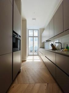 una cucina con pavimenti in legno e una grande finestra di Luxury Home / 3-Raum-Suite an der Frauenkirche / 4 a Dresda