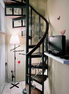 a black spiral staircase with a television and a lamp at La Casetta in Montefegatesi