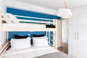 a bedroom with bunk beds with a blue accent wall at Glyfada Luxury Living in Athens