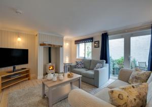 uma sala de estar com um sofá e uma televisão em St Mellyn em Mevagissey