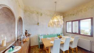 a dining room with a table and chairs and a chandelier at Villa Zeitouni in Nisakion