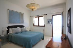 a bedroom with a bed with a blue blanket and a window at Villa Zeitouni in Nisakion +42 photos