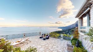 a house with a balcony with a view of the ocean at Villa Zeitouni in Nisakion