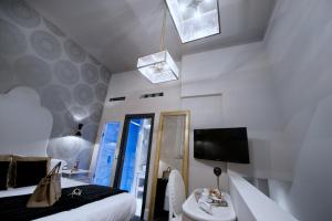 1 dormitorio con cama, espejo y TV en HT6 Hotel Roma en Roma