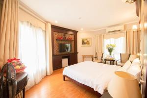 1 dormitorio con 1 cama blanca y sala de estar en A25 Hotel - 23 Quán Thánh, en Hanói