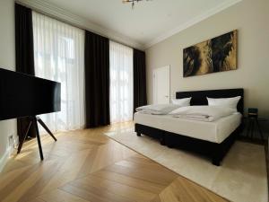 a bedroom with a bed and a flat screen tv at Luxury Home / 3-Raum-Suite an der Frauenkirche / 4 in Dresden