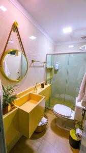 a bathroom with a sink and a toilet and a mirror at Casa com os pés no mar em Iriri ES in Anchieta