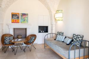 sala de estar con sofá, sillas y mesa en Masseria Santo Scalone, en Ostuni