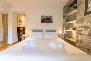 a bedroom with a large white bed with two towels at Ca Sbrisiga in Moltrasio in Moltrasio
