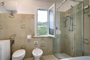 a bathroom with a toilet and a shower and a window at Casa Luci in Levanto