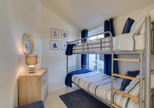 a bedroom with two bunk beds and a desk at Chy Vean in Padstow