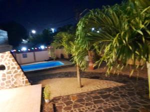 a palm tree sitting next to a swimming pool at night at 3 bedrooms villa with city view shared pool and enclosed garden at Pointe aux Piments 1 km away from the beach in Pointe aux Piments