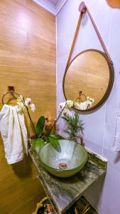 een badkamer met een groene wastafel en een spiegel bij Casa com os pés no mar em Iriri ES in Anchieta