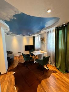 uma sala de estar com uma mesa e cadeiras verdes em LifeStyle Apartment Sinsheim em Sinsheim
