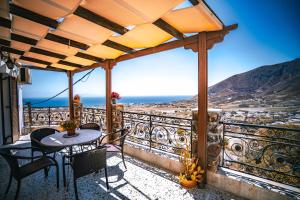 a patio with a table and chairs on a balcony at Morning Star Traditional Houses in Pyrgos