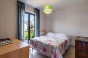 a bedroom with a bed and a desk and a window at Siliqua House with Garden by Wonderful Italy in Trecastagni