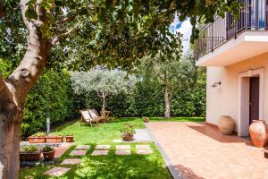 a garden with a tree and a house at Siliqua House with Garden by Wonderful Italy in Trecastagni